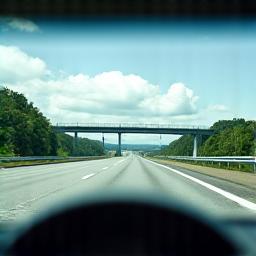 Vista desde el interior de un coche pasando por un carril de telepeaje sin detenerse.